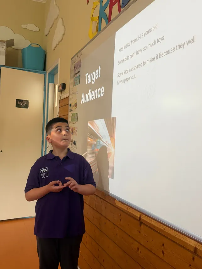 Students pointing to a target audience diagram during a business pitch class