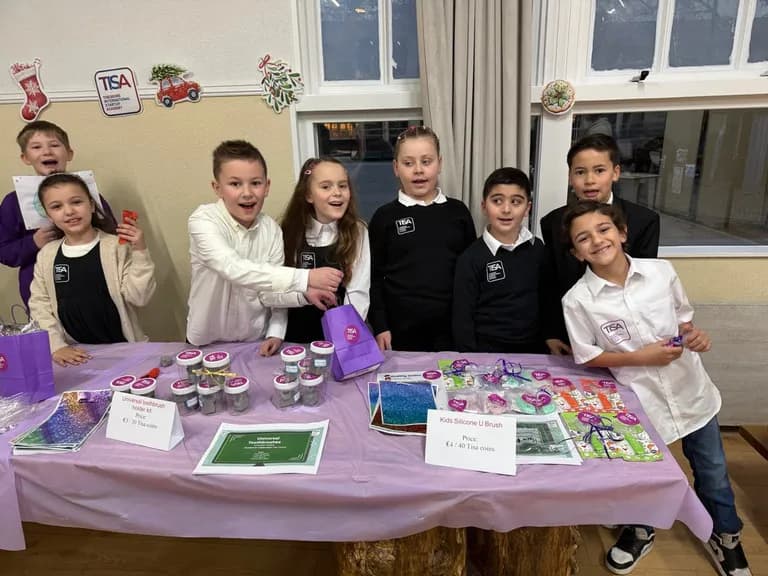 TISA students selling their products at the school market stall under the TISA sign