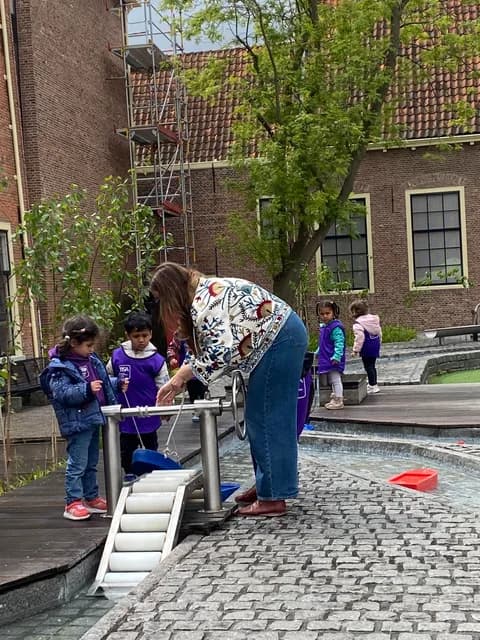 Teacher and students operating a water pump and sluice during a STEM lesson