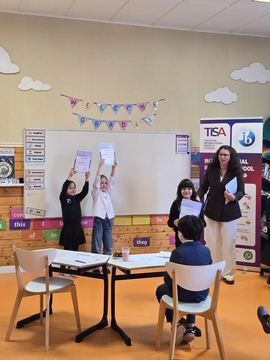 TISA Business students holding certificates with their teacher and the IB banner