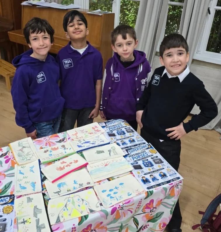 Four TISA MBA students behind their hand-decorated purses for sale