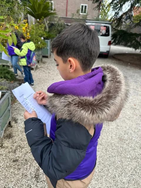 Student completing a garden observation worksheet outdoors at TISA Leiden