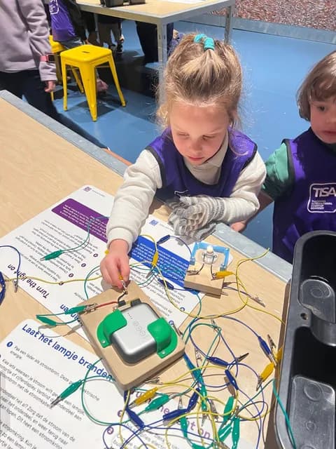 TISA student in a school vest building an electronic circuit