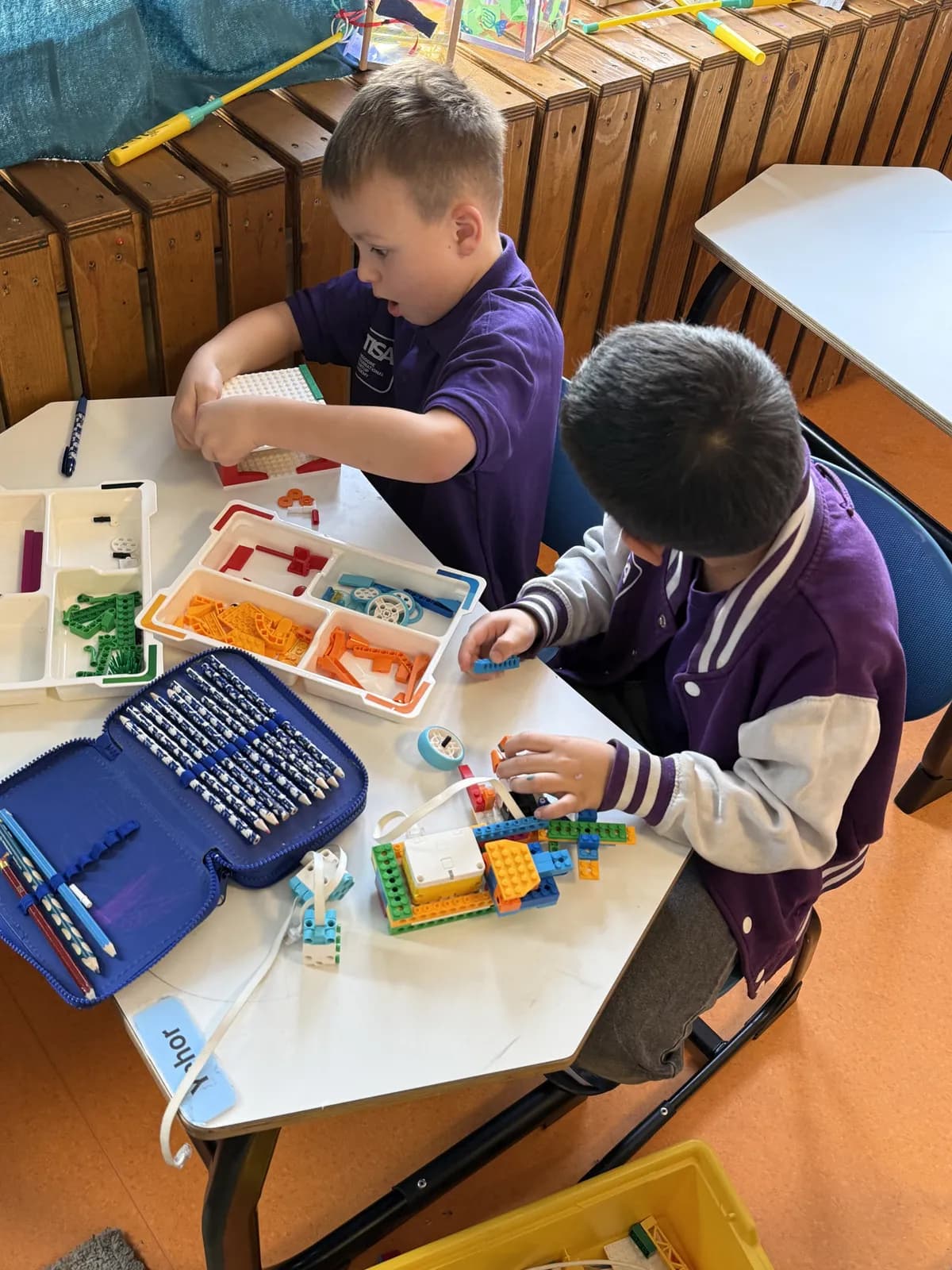 TISA students collaborating on a LEGO robotics build seen from above
