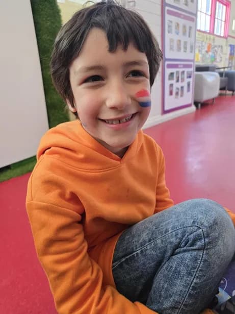 TISA student with Dutch flag face paint smiling during the Kings Day celebration