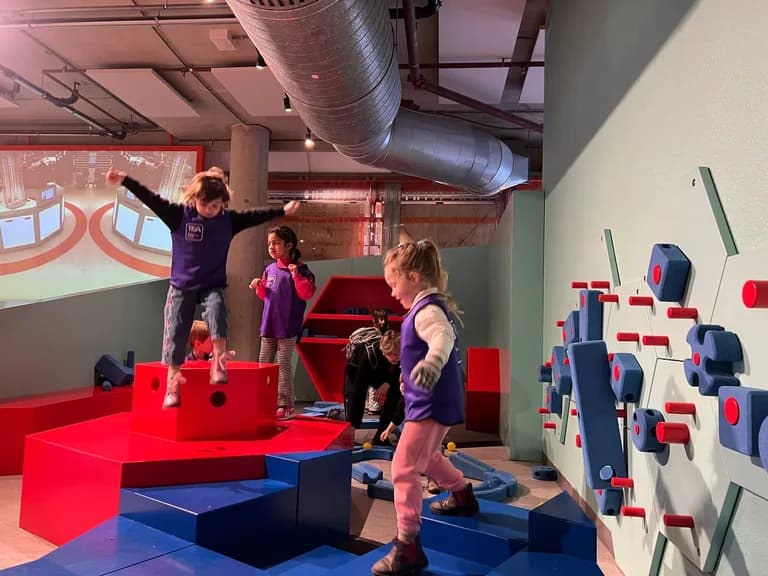 Children joyfully climbing colorful foam blocks at a museum play exhibit