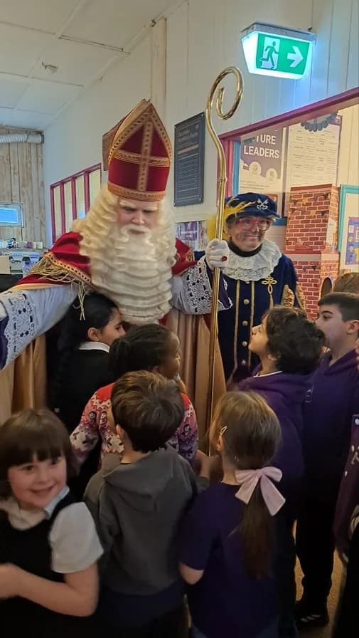 Sinterklaas greeting a group of excited TISA students outdoors