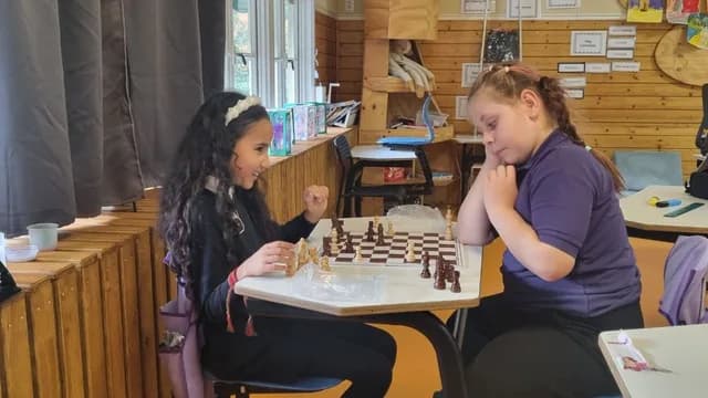 Two TISA students playing chess together in the classroom
