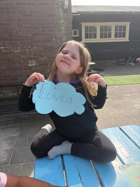 A young student enjoying lunch at a sunny picnic table in the schoolyard
