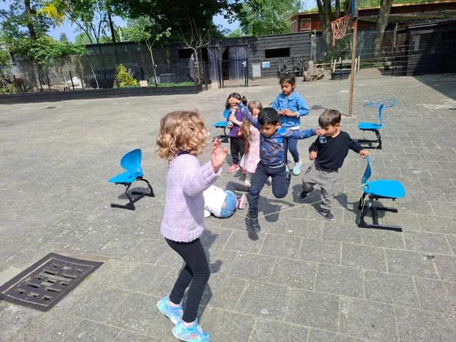 Young children playing and running outdoors at TISA