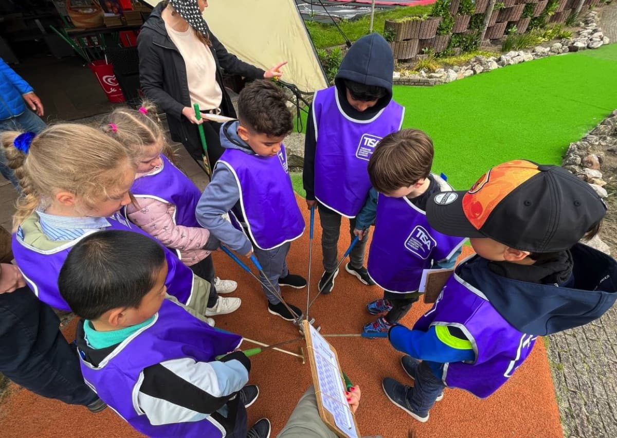 TISA summer camp children on an outdoor activity in their purple camp vests